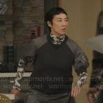 Stella’s grey short sleeve sweatshirt, printed turtleneck, and grey pleated skirt on The Morning Show