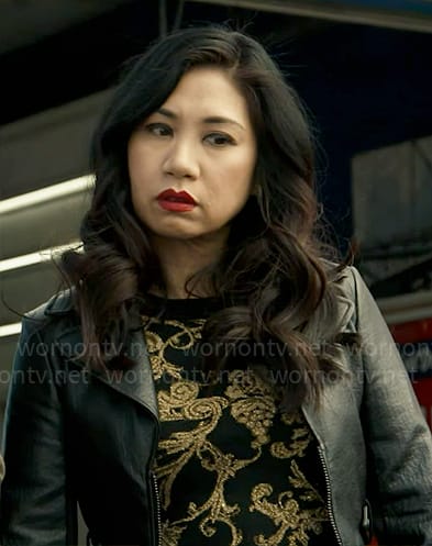 Mel’s black and gold flourish print top and leather jacket on The Equalizer