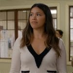 Nell’s white sweater with black trim and pinstripe mini skirt on Not Dead Yet