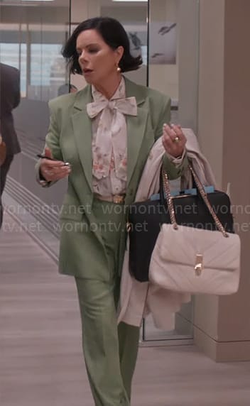 Margaret’s floral tie neck blouse and green suit on So Help Me Todd