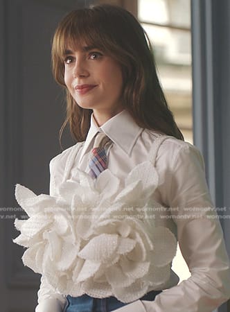 Emily’s white ruffle top and plaid tie on Emily in Paris