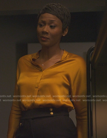 Jax’s gold satin blouse on Reasonable Doubt