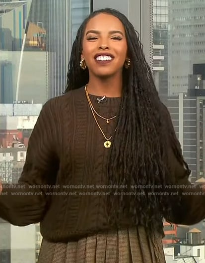 Mona’s brown cable knit sweater and mini skirt on Extra