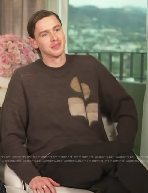 Harris Dickinson’s brown logo sweater on Access Hollywood
