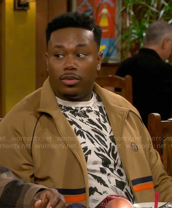 Marty’s painted print t-shirt and camel striped jacket on The Neighborhood