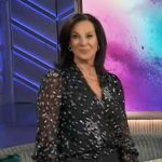 Emily Kaufman’s black dotted sheer wrap top on The Kelly Clarkson Show