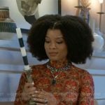 Eva’s orange printed top on Beyond the Gates
