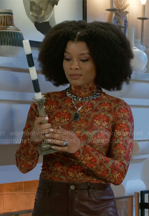 Eva’s orange printed top on Beyond the Gates