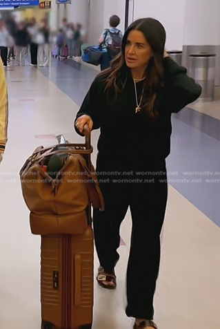 Kyla’s black leather slide sandals and brown suitcase on The Real Housewives of Beverly Hills