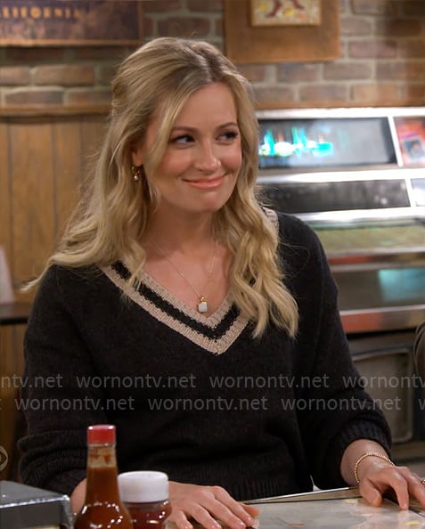 Gemma’s black v-neck sweater with striped trim on The Neighborhood