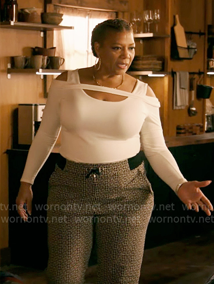 Robyn’s white cutout shoulder sweater and monogram print pants on The Equalizer