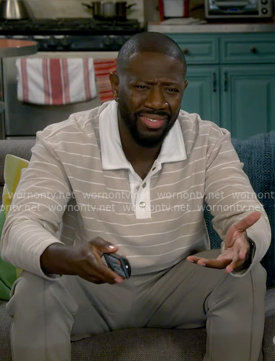 Malcolm’s light beige striped polo shirt on The Neighborhood