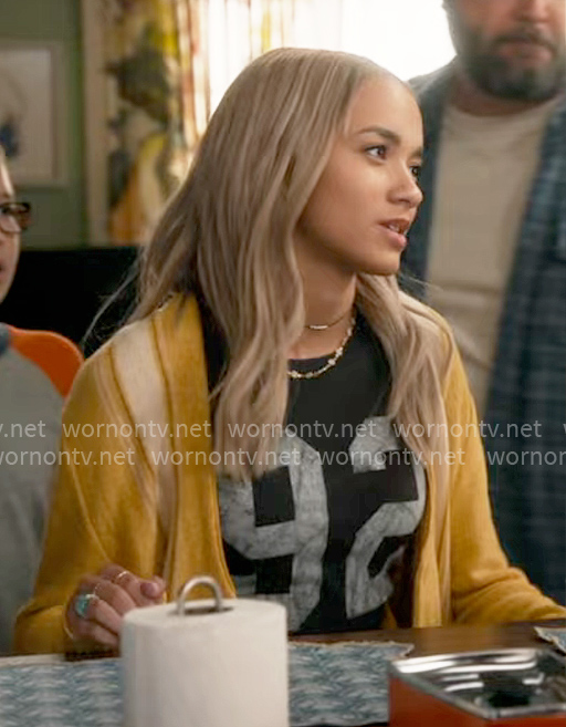 Ava’s 92 tee and yellow cardigan on High Potential