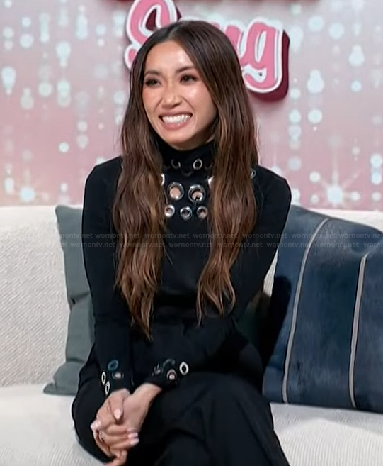 Brenda’s black grommet embellished sweater on Access Hollywood