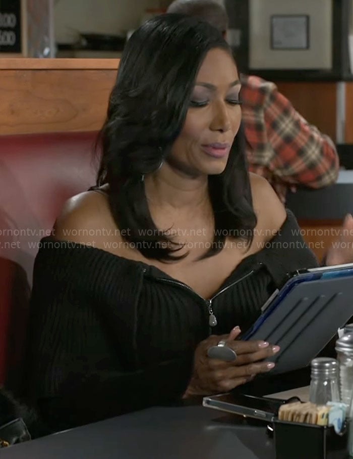Leslie’s black zip-up off-shoulder sweater on Beyond the Gates
