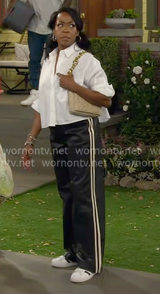 Tina’s white cropped shirt and faux leather track pants on The Neighborhood