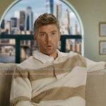 Kyle’s beige stripe confessional polo sweater on In The City