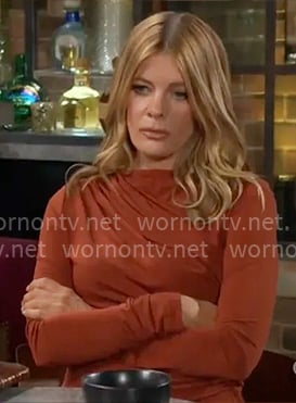 Phyllis’s rust brown draped top and metallic clutch on The Young and the Restless