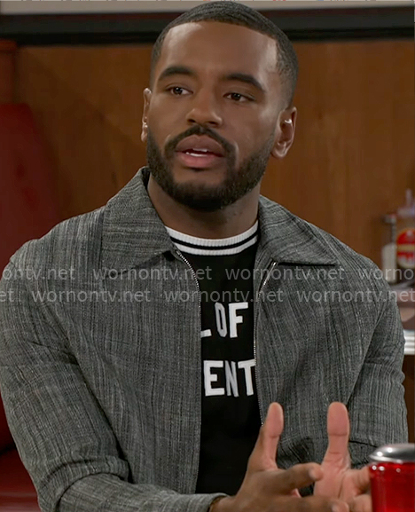 Andre’s text t-shirt and grey jacket on Beyond the Gates