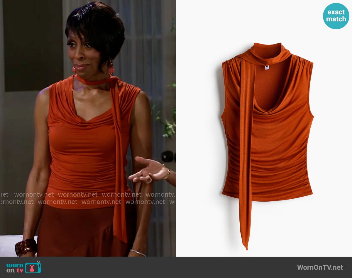 H&M Top with Scarf Collar in Dark Orange worn by Sharon Winger (Bonita Brisker) on Beyond the Gates H&M Top with Scarf Collar in Dark Orange worn by Sharon Winger (Bonita Brisker) on Beyond the Gates